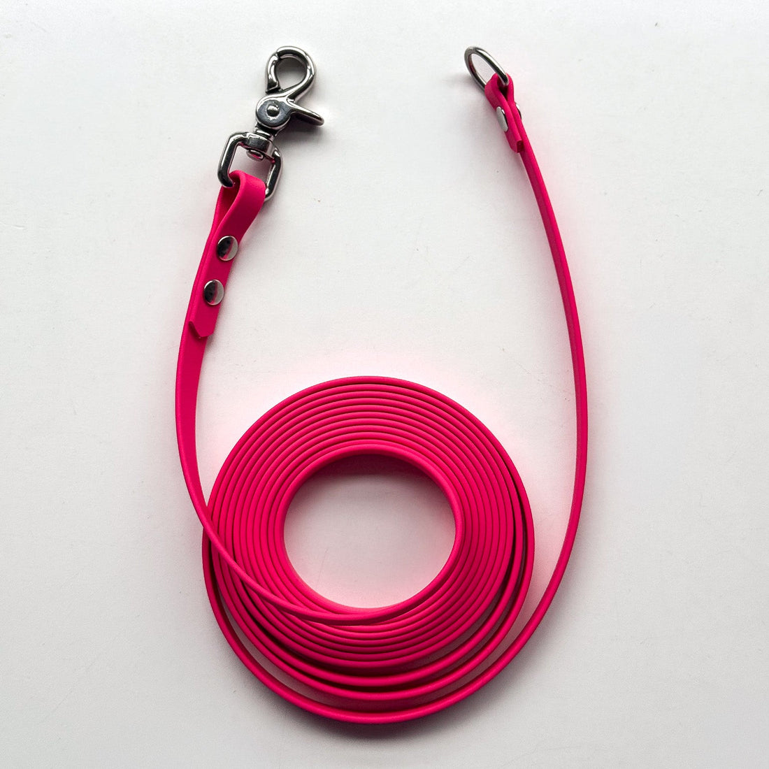 Pink dog leash with metal clip on a white background