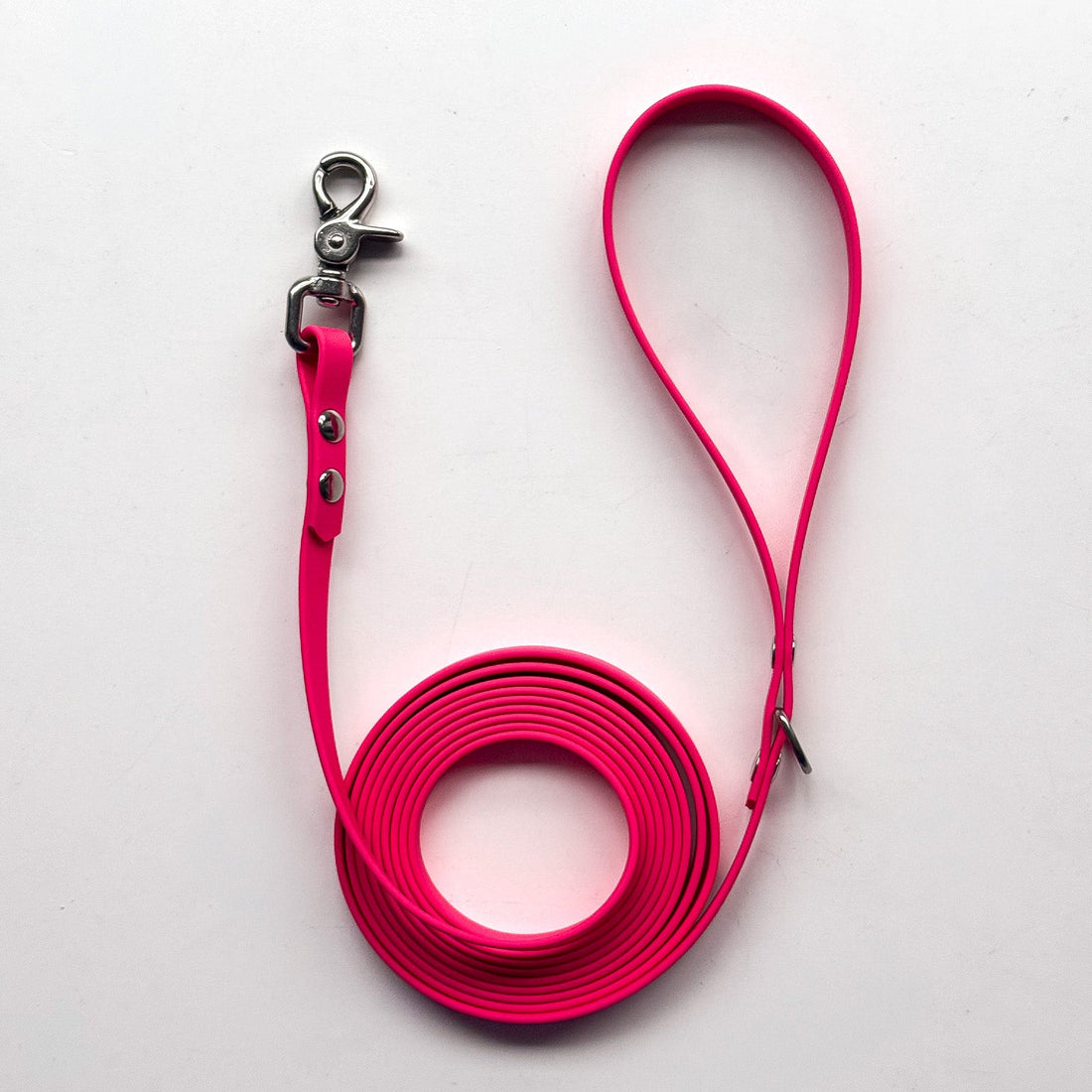 Pink dog leash with clip on a white background