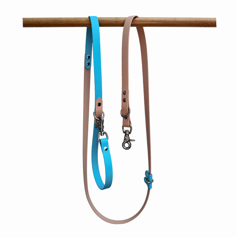 Sand and light blue Biothane dog lead on a wooden rack against a white background