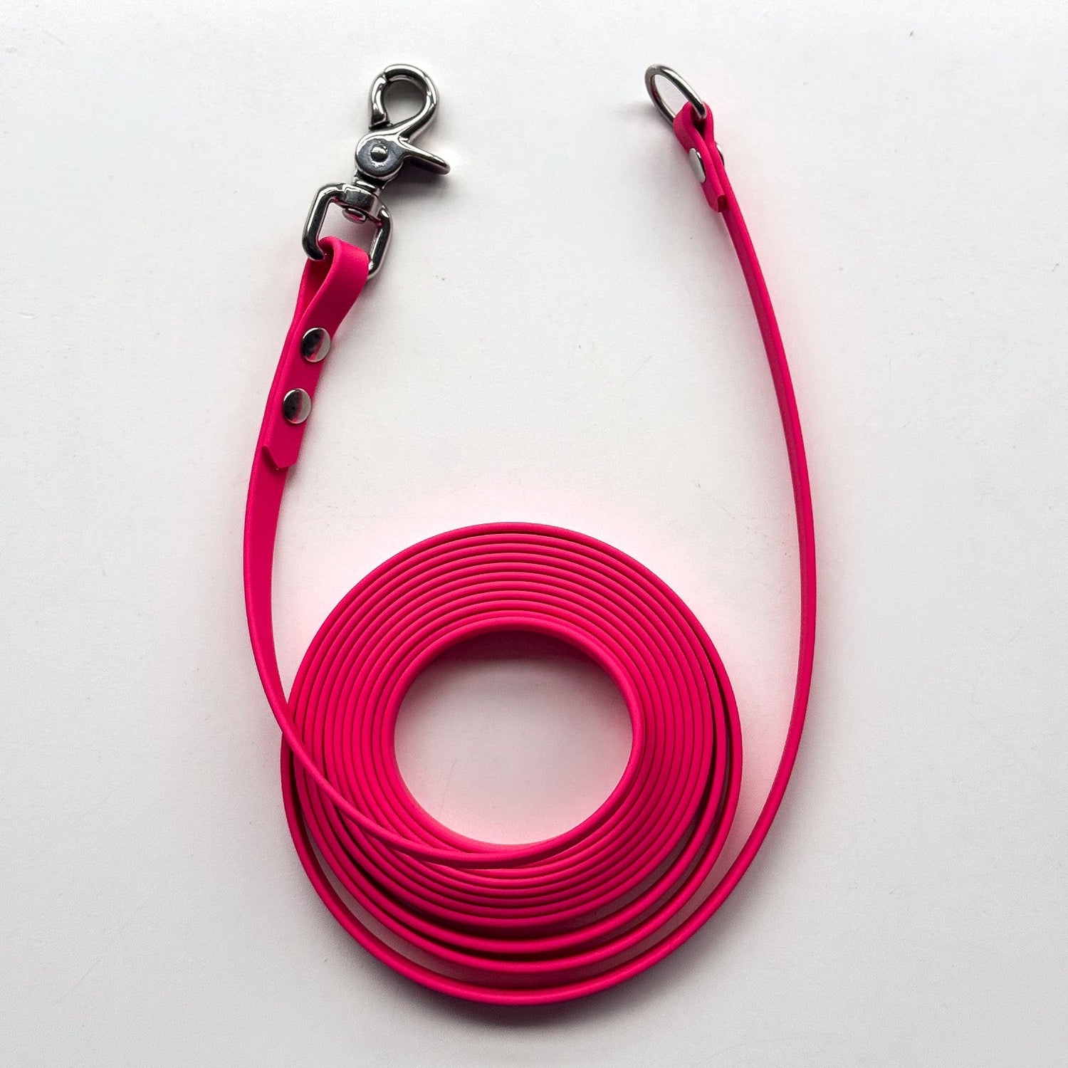 Pink dog leash with metal clip on a white background