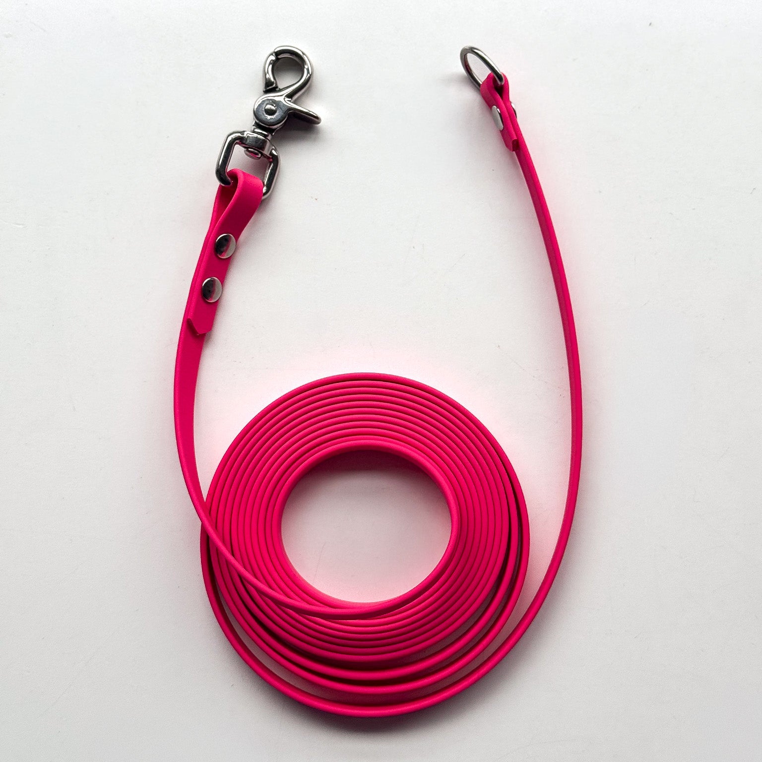 Pink dog leash with metal clip on a white background