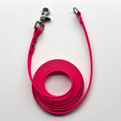 Pink dog leash with metal clip on a white background